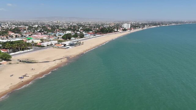 Aerial drone view of Benguela beach in Angola, showing long golden coastline, calm turquoise waters, and bright tropical atmosphere