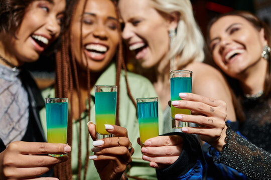 Friends celebrating together with colorful drinks at a lively party venue filled with joy