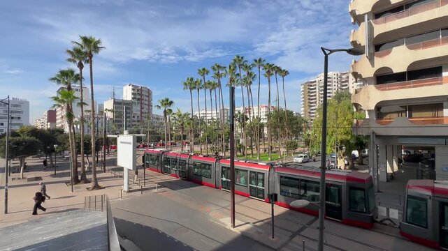 Modern red tramway in downtown Casablanca Morocco, urban public transportation with cars and buildings on a sunny day, African city travel and daily commute Casablanca train station, Morocco. 