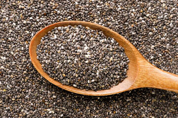 Chia seeds in a wooden spoon background. Top view