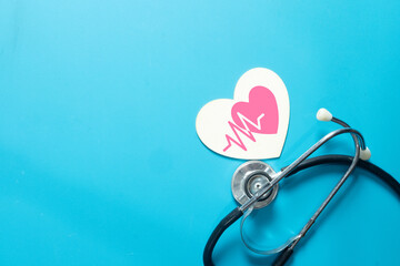 Heart health and cardiology concept. Medical stethoscope near a heart shape with a heartbeat pulse line on a blue background, symbolizing healthcare, check-up, and insurance with copy space.