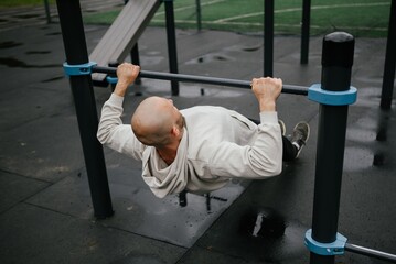 Man Performing Inverted Row on Outdoor Gym Equipment