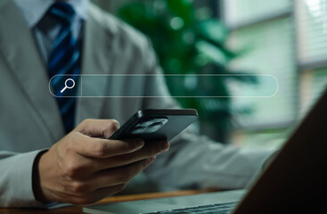 professional using a smartphone and laptop with a digital search bar overlay represents online searching, mobile technology, and modern work, highlighting communication, efficient information access.