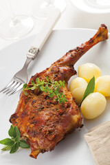 Roast leg of kid goat with boiled potatoes.