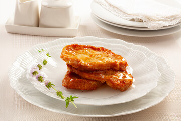French toast dipped in honey and served on an elegant plate.