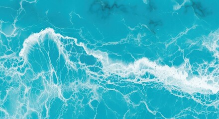 Aerial view of ocean waves crashing on the shore, creating white foam.