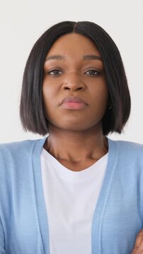 Portrait of a displeased young African American woman frowning and showing skepticism. She looks annoyed and judgmental isolated on white background.