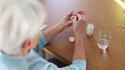 Senior woman taking her medication at home, close-up of hands
 - Powered by Adobe