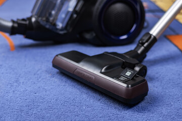 Modern vacuum cleaner with brush on carpet in room