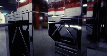 Reflective metal turnstiles stand at the entrance of a busy subway station, capturing the essence of urban commuting during peak travel times.