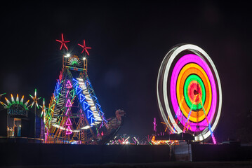 Vibrant rides in the Colorful Giant Ferris wheel with night illumination in the funfair, Maharashtra, India.