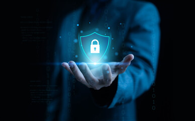 A futuristic cybersecurity concept showing a glowing shield with a lock icon hovering above a businessman’s hand, symbolizing data protection, digital safety, encryption, and modern secure technology.