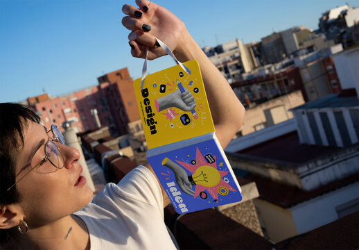 Woman holding a square notebook with a front and back cover by the elastic band