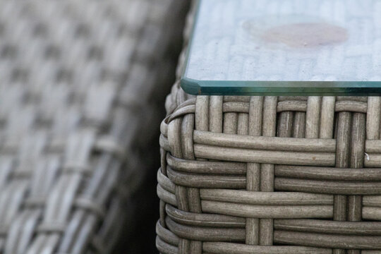 Close-up of synthetic rattan garden furniture texture with glass table corner