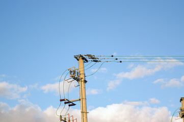Słup elektryczny na tle nieba, beton, metal.