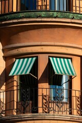 Green striped awnings on curved historic building facade