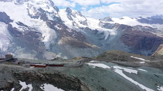 Mountain train on a scenic route with snow mountains in the background