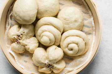 Overhead view of steamed bun in a steamer basket, top view of mantou in a bamboo steamer