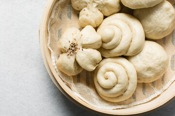 Overhead view of steamed bun in a steamer basket, top view of mantou in a bamboo steamer