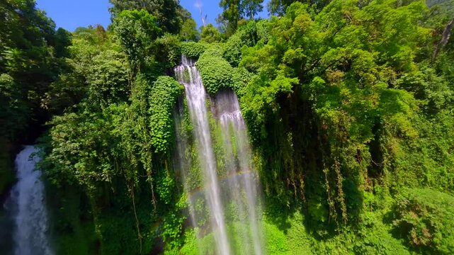 Cinematic FPV drone dive over Sekumpul Waterfall in Bali, Indonesia. Aerial view of tropical jungle and powerful cascading water perfect for nature, travel, and adventure themes.
