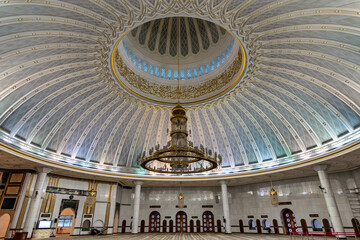 Jame Asr Hassanil Bolkiah Mosque interior, Brunei Darussalam. Majestic dome with intricate gold patterns, elegant Arabic calligraphy, and a grand chandelier illuminating the spacious prayer hall