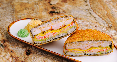 Crispy sushi sandwich served on a white plate with colorful garnishes