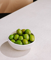 Fresh green olives served in a small bowl on a dining table