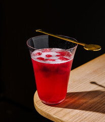 Refreshing red drink served in a stylish glass on a wooden table