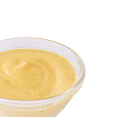 Mustard dressing in a clear bowl on a white background