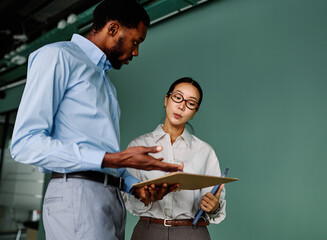Portrait of young businesswoman and businessman using a tablet having a meeting or presentation and seminar in the office