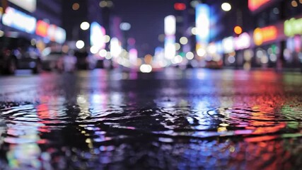 Dynamic urban night scene: rain ripples on wet street reflecting colorful bokeh city lights and neon signs - Powered by Adobe