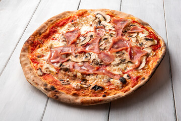 Pizza italiana condita con prosciutto cotto e funghi champignon 