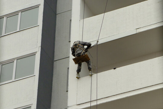 Industrial Abseiler Working on the High-Rise Facade with a Swinging Seat