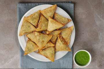 Crispy Fried Samosa Triangle Snacks Served on Plate with Green Dip