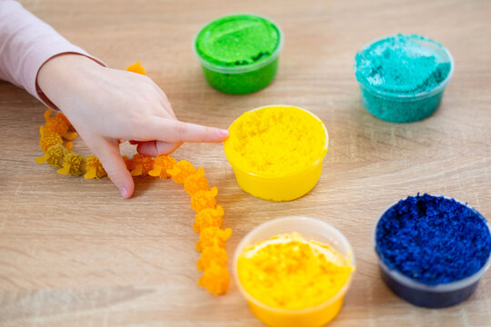 child, girl molds shaping foam clay and stretching slime. Hands-on creative fun and sensory development for children, fine motor skills Development, Learning Through Play