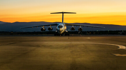 Military cargo aircraft. Large cargo aeroplane landed at the airport on a beautiful sunset