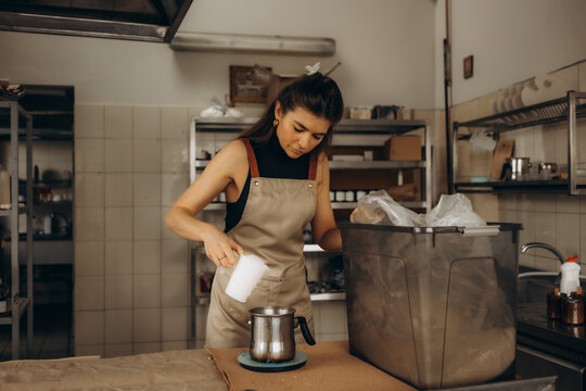 Woman weighing wax for handmade candle making - Powered by Adobe