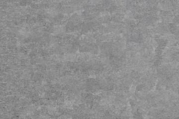 A uniform gray background featuring a subtly rough, mottled texture with slight variations in...