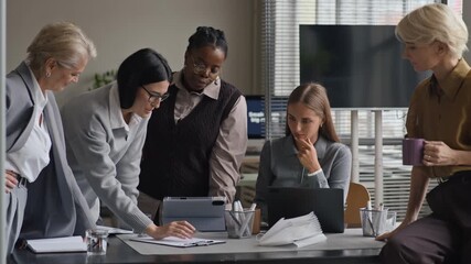 Medium long shot of inspired multiethnic female business team of different age brainstorming together in modern office and sharing creative ideas - Powered by Adobe