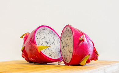 Fresh Pink Dragon Fruit (Pitaya) Cut in Half, Revealing White Flesh and Seeds on Wooden Board