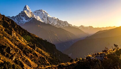 Majestic snow-capped mountain peak lit by the sunrise, with grassy slopes in the foreground and valley in the distance