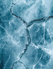 Abstract aerial view of deep cracks and fissures fracturing the surface of a frozen blue lake, creating a natural textured background