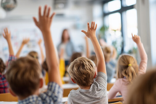 Engaged group of schoolchildren raising their hands during a lesson, showing participation, curiosity, and active learning in a bright modern classroom. - Powered by Adobe