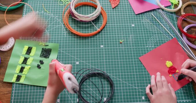 Little children draw textured patterns with 3d pens together in design studio. Schoolkids study basic of design technology in classroom. Engineering creativity