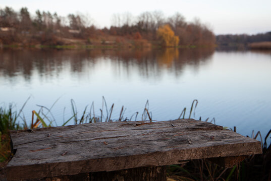 Wooden bench overlooking calm autumn lake - Powered by Adobe