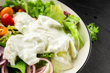 Burrata salad tomato, purple onion, green leaf lettuce tasty snack fresh gourmet food table setting rustic food top view copy space keto and paleo diet vegetarian food