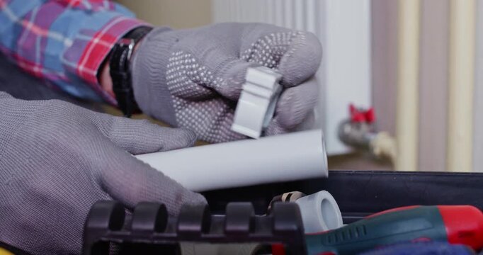 Worker tests stainless clamp on PPR tee checking diameter. Installer slides band to socket shoulder while confirming snug engagement for fit during maintenance process