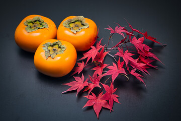 美しく紅葉したもみじの葉と秋の代表的な果物の柿