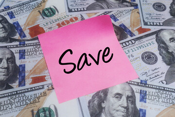 Pink sticky note with Save on US dollar bills, symbolizing financial prudence, strategic savings,...