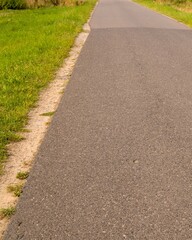 Obraz premium Empty asphalt road leading through green fields in germany
